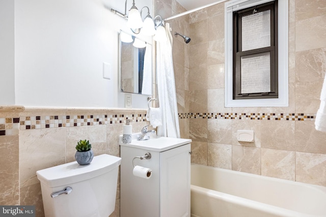 full bathroom with toilet, tile walls, wainscoting, shower / tub combo, and vanity