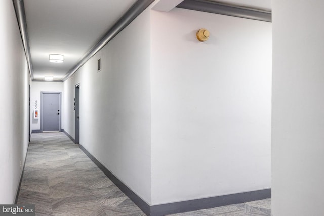 corridor featuring carpet flooring, baseboards, and visible vents