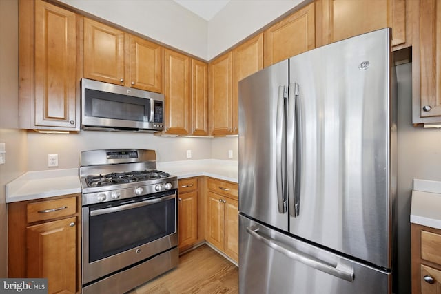 kitchen featuring stainless steel appliances, light countertops, and light wood-style floors