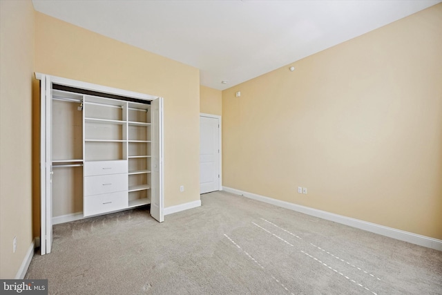 unfurnished bedroom featuring a closet, baseboards, and carpet