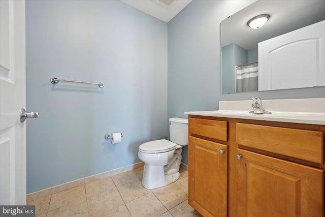 bathroom with tile patterned flooring, toilet, vanity, and baseboards