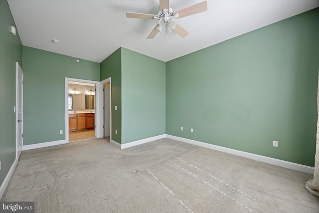 unfurnished bedroom featuring connected bathroom, baseboards, light carpet, and a ceiling fan