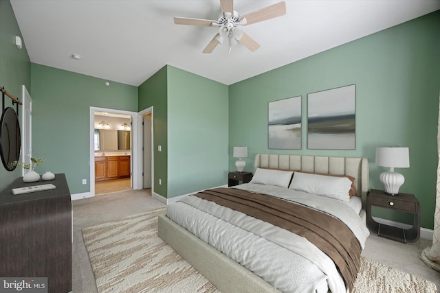 bedroom featuring ceiling fan, baseboards, ensuite bathroom, and carpet flooring