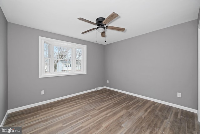 unfurnished room with visible vents, a ceiling fan, baseboards, and wood finished floors