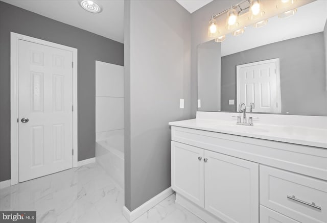 bathroom with baseboards, a bathtub, marble finish floor, and vanity