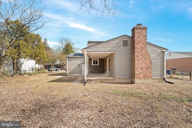 back of property with a patio area and a chimney