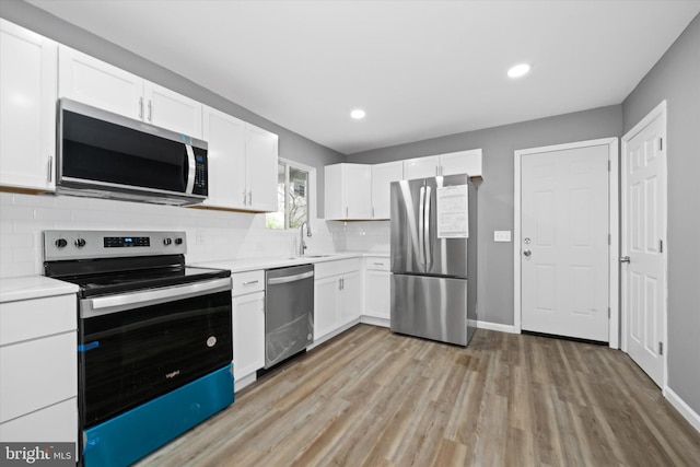 kitchen featuring appliances with stainless steel finishes, light countertops, and white cabinetry