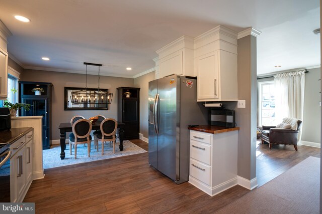 kitchen with ornamental molding, dark wood-style flooring, stainless steel refrigerator with ice dispenser, and white cabinetry