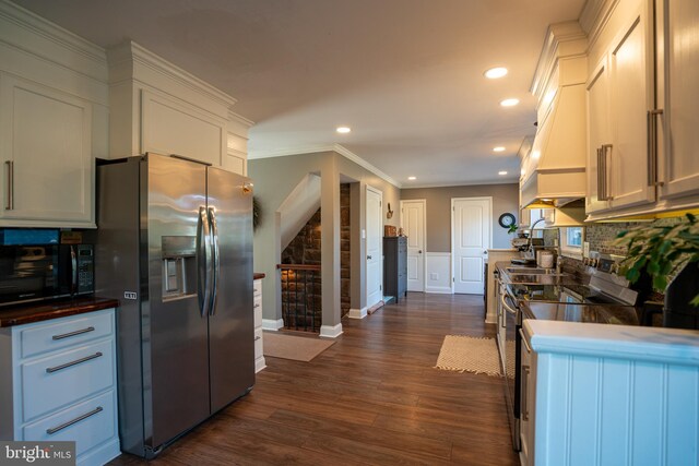 kitchen featuring ornamental molding, dark wood finished floors, recessed lighting, stainless steel appliances, and white cabinets