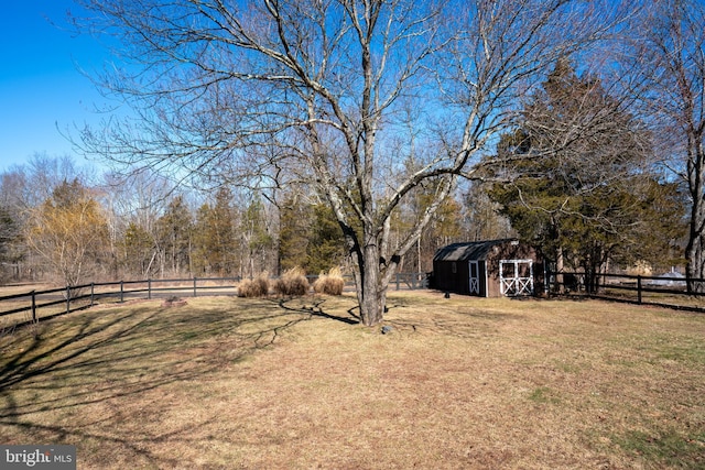 view of yard with a storage shed, an outdoor structure, and fence