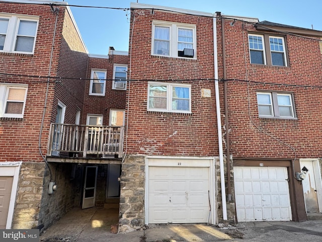 rear view of property featuring an attached garage and brick siding