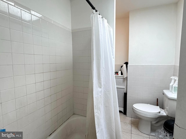 bathroom featuring tile patterned floors, shower / bathtub combination with curtain, a wainscoted wall, toilet, and tile walls