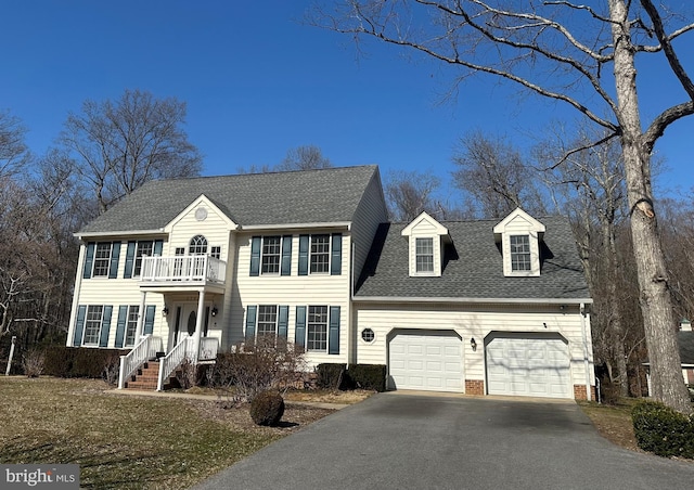 view of front of home with a garage, a balcony, roof with shingles, and driveway