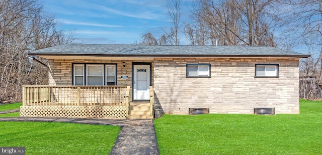 view of front of home with crawl space, covered porch, a front yard, and a shingled roof