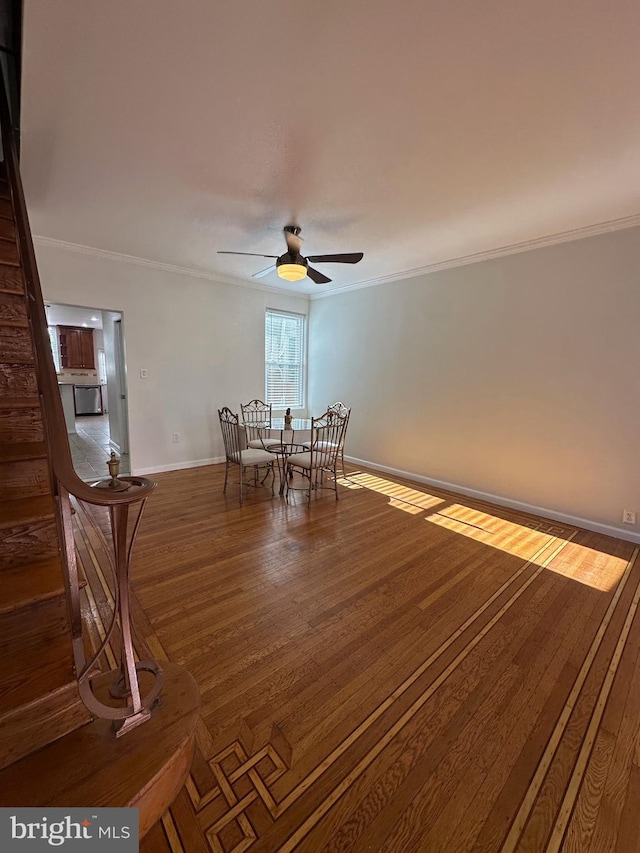 interior space featuring ceiling fan, baseboards, wood finished floors, and ornamental molding