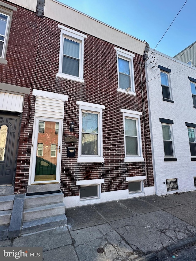 townhome / multi-family property featuring brick siding and entry steps