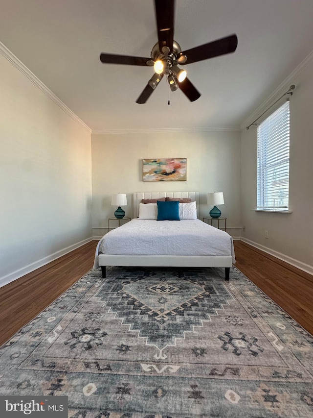 bedroom featuring ceiling fan, baseboards, wood finished floors, and crown molding