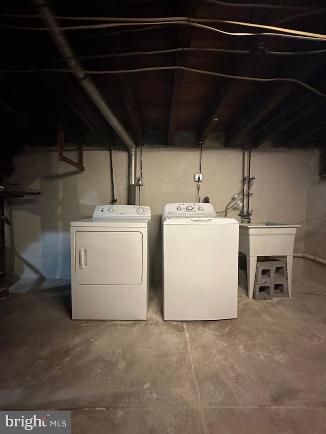 clothes washing area with a sink, laundry area, and washer and clothes dryer