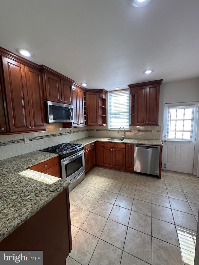 kitchen with tasteful backsplash, open shelves, light tile patterned flooring, stainless steel appliances, and a sink