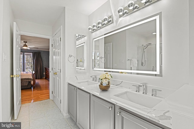 ensuite bathroom featuring double vanity, tile patterned flooring, a shower, and a sink