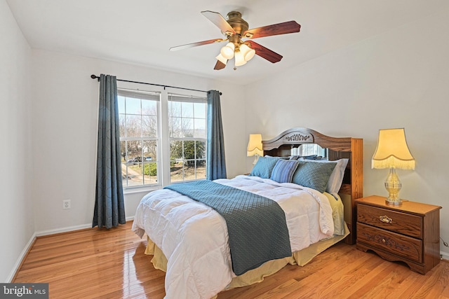 bedroom with baseboards, light wood finished floors, and ceiling fan