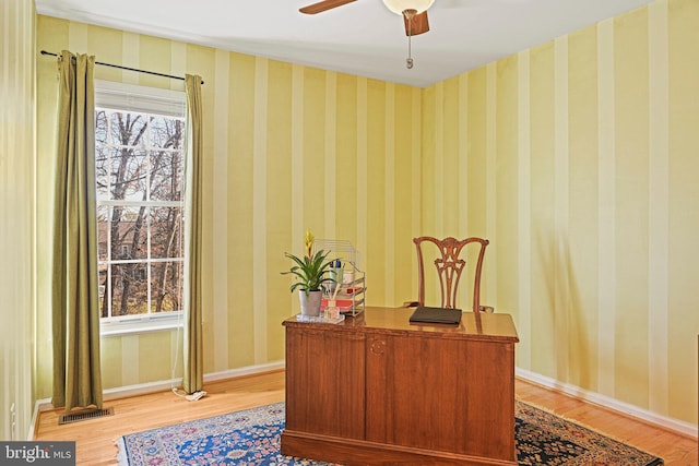 office area with baseboards, visible vents, wallpapered walls, and a ceiling fan