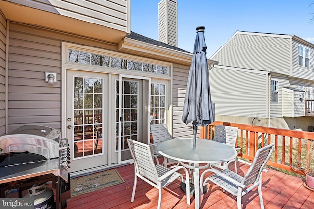 deck with a grill and outdoor dining area