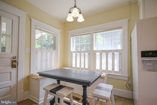 dining area with crown molding, baseboards, and a chandelier