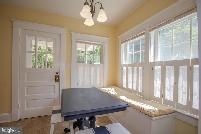 exercise area featuring a notable chandelier and crown molding