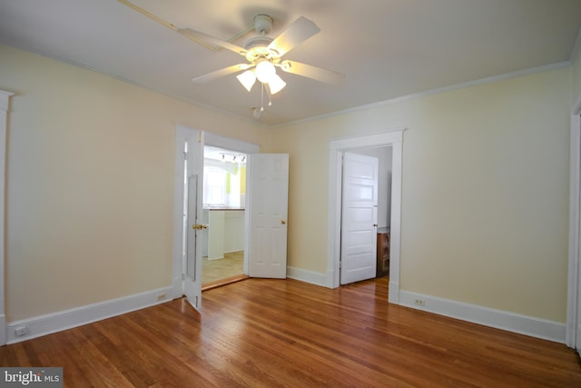 unfurnished bedroom with ceiling fan, baseboards, wood finished floors, and ornamental molding