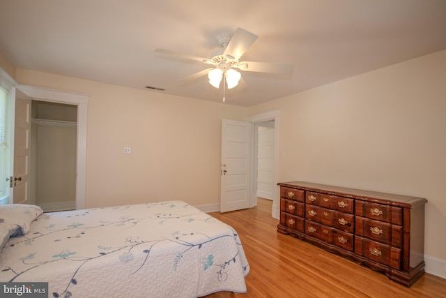 bedroom featuring visible vents, baseboards, light wood-style floors, and a ceiling fan