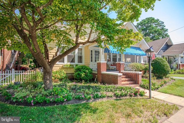 view of front of house with brick siding and fence