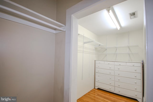 walk in closet with wood finished floors and visible vents