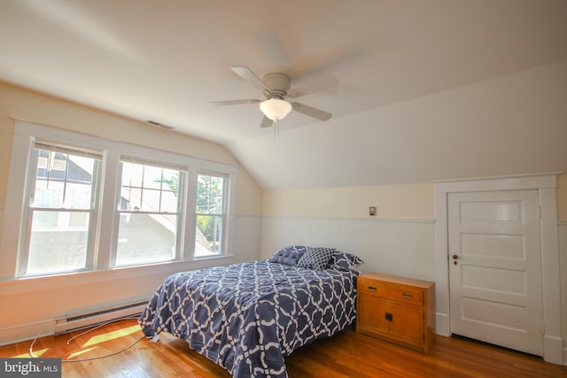 bedroom with visible vents, dark wood finished floors, lofted ceiling, wainscoting, and baseboard heating