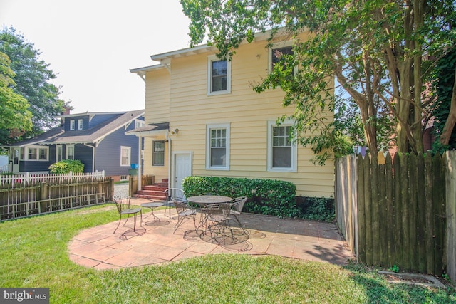 back of property with entry steps, a patio area, a yard, and fence private yard