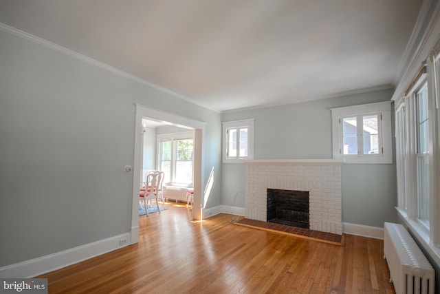 unfurnished living room with hardwood / wood-style flooring, radiator heating unit, a fireplace, and baseboards