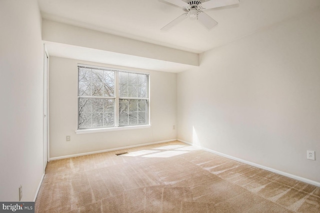 empty room featuring carpet flooring, visible vents, baseboards, and ceiling fan