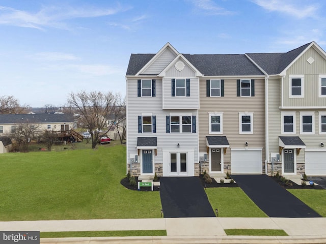 view of property with stone siding, board and batten siding, driveway, and a front yard