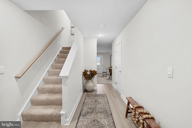 stairway with baseboards and wood finished floors