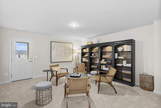 sitting room featuring baseboards, visible vents, and carpet floors