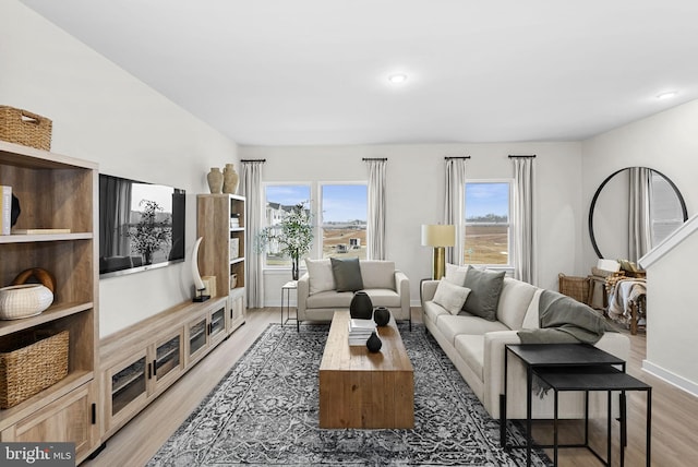 living area featuring recessed lighting, baseboards, a healthy amount of sunlight, and light wood finished floors