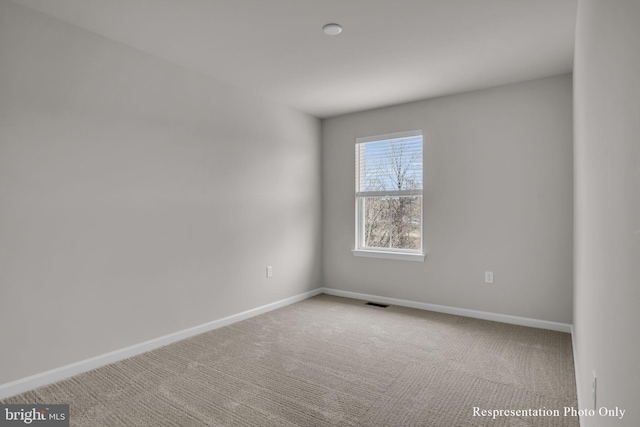 unfurnished room with visible vents, baseboards, and carpet