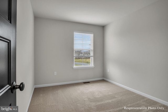 carpeted empty room featuring visible vents and baseboards