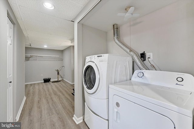 clothes washing area featuring laundry area, independent washer and dryer, light wood-style floors, and baseboards