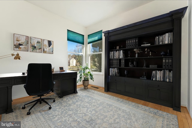 office with visible vents, baseboards, and wood finished floors