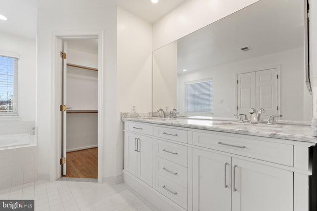 full bathroom featuring double vanity, visible vents, tile patterned floors, and a sink