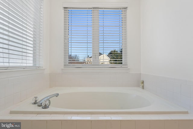 bathroom with a healthy amount of sunlight and a bath