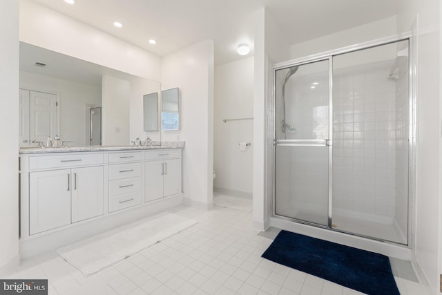 full bath featuring double vanity, a stall shower, toilet, and a sink