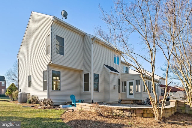 back of property featuring cooling unit, a lawn, and entry steps