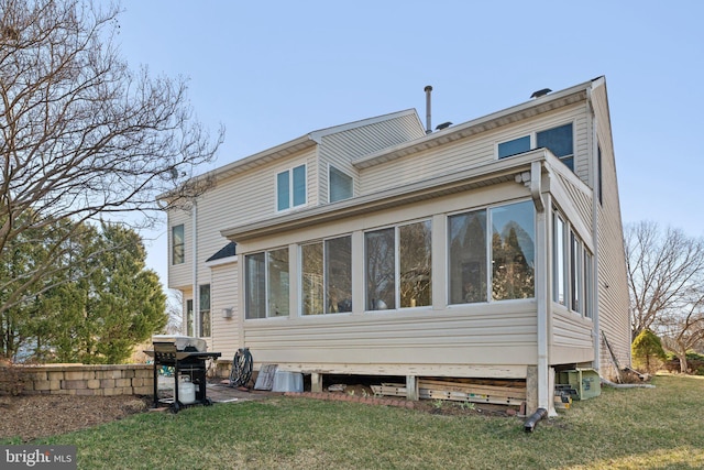 back of property featuring a yard and a sunroom